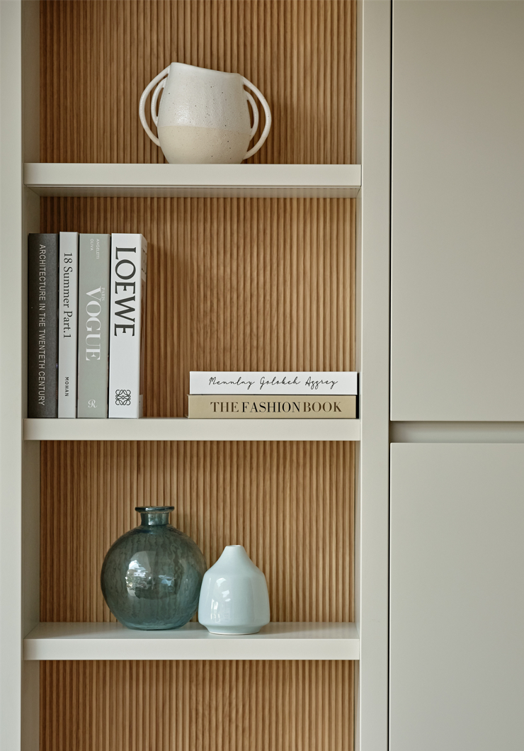 Bespoke joinery detail showing open shelving in beige and fluted oak back panels