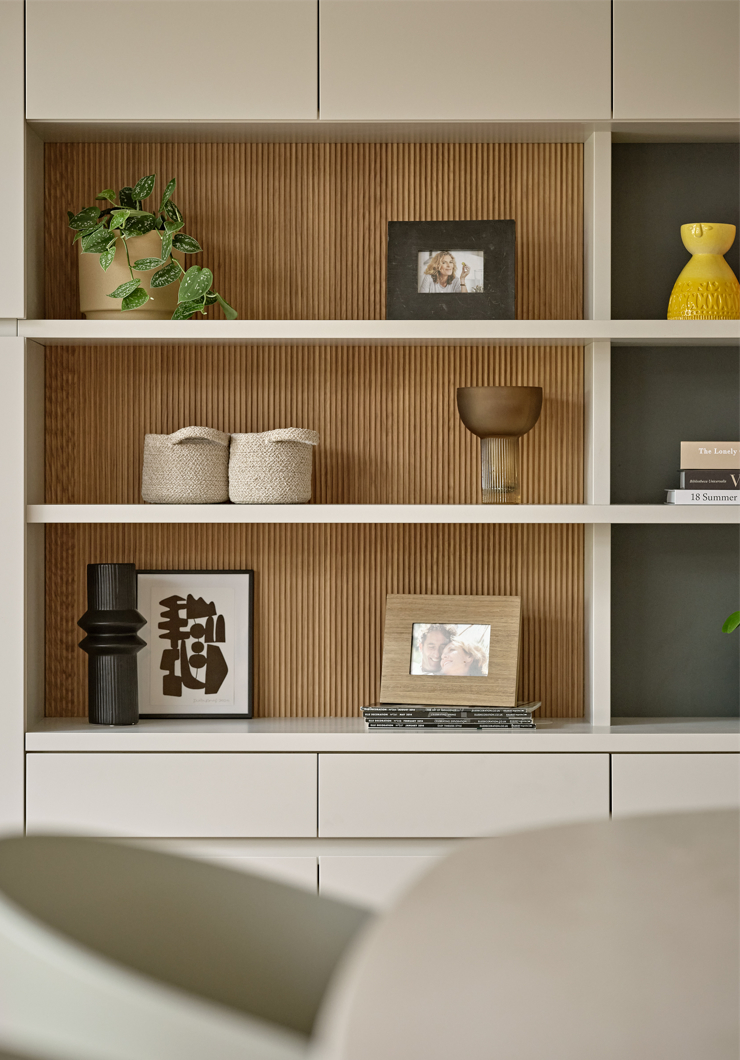Contemporary bespoke fitted wall unit in beige colour with oak fluted detailing and open shelving.