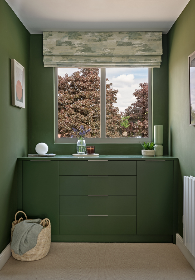 Green fitted contemporary chest of drawers and cupboards in dressing room